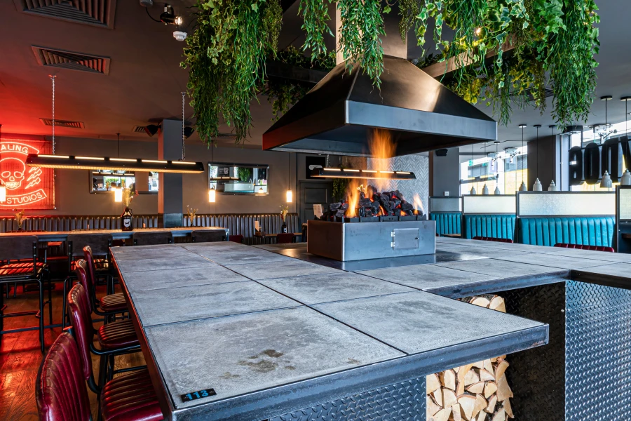 Artificial foliage suspended above open fireplace in bar